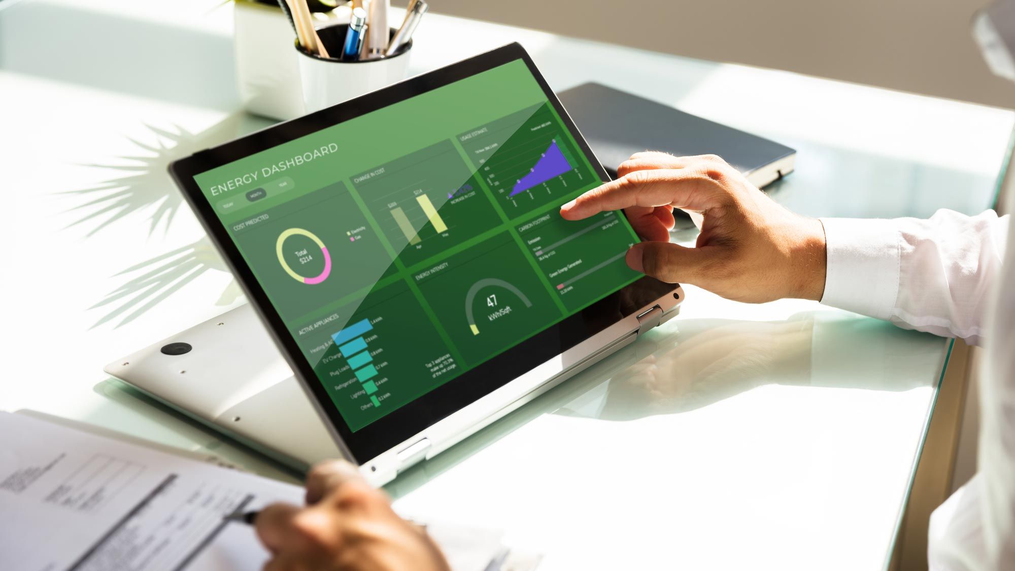 A person analyzing energy data on a tablet with graphs.