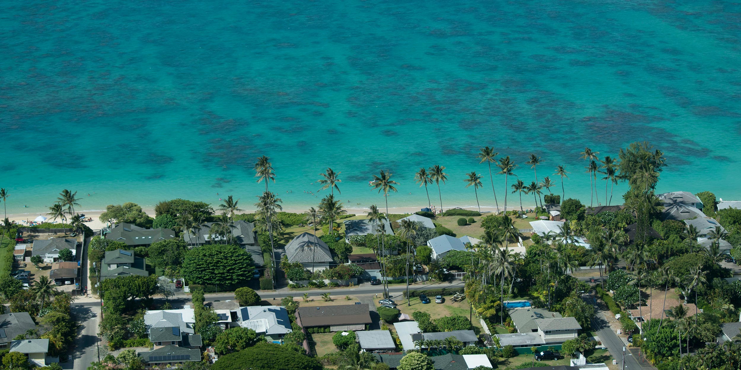 Aerial view of beachfront homes and turquoise ocean water