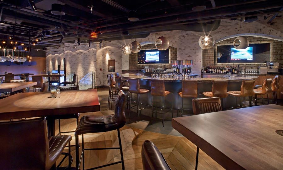 A restaurant and bar with in-ceiling speakers and flat-screen TVs.