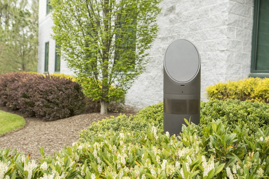 A Coastal Source outdoor speaker among the bushes.