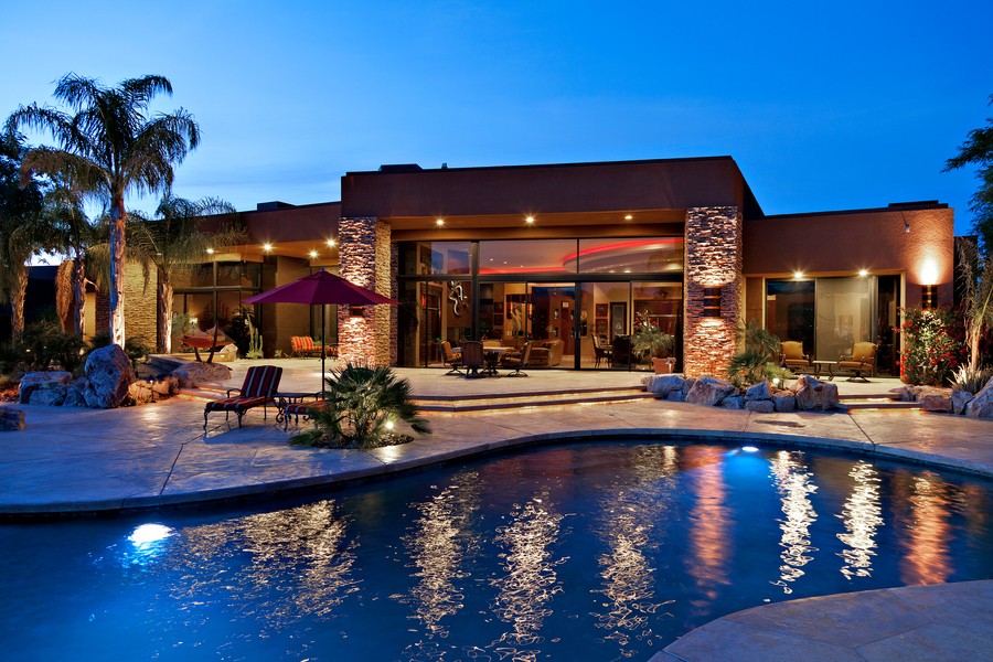 Image is of a hospitality event space with a pool and palm trees.